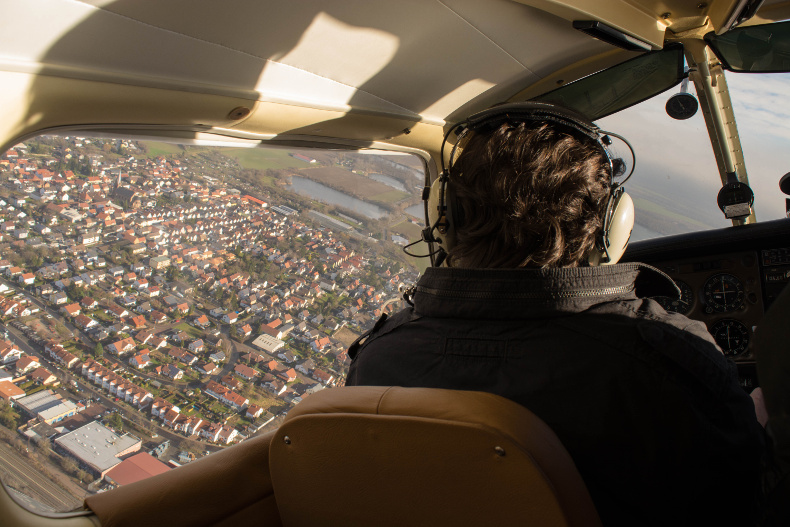 Blick auf Piloten bon hinten im fliegenden Flugzeug 